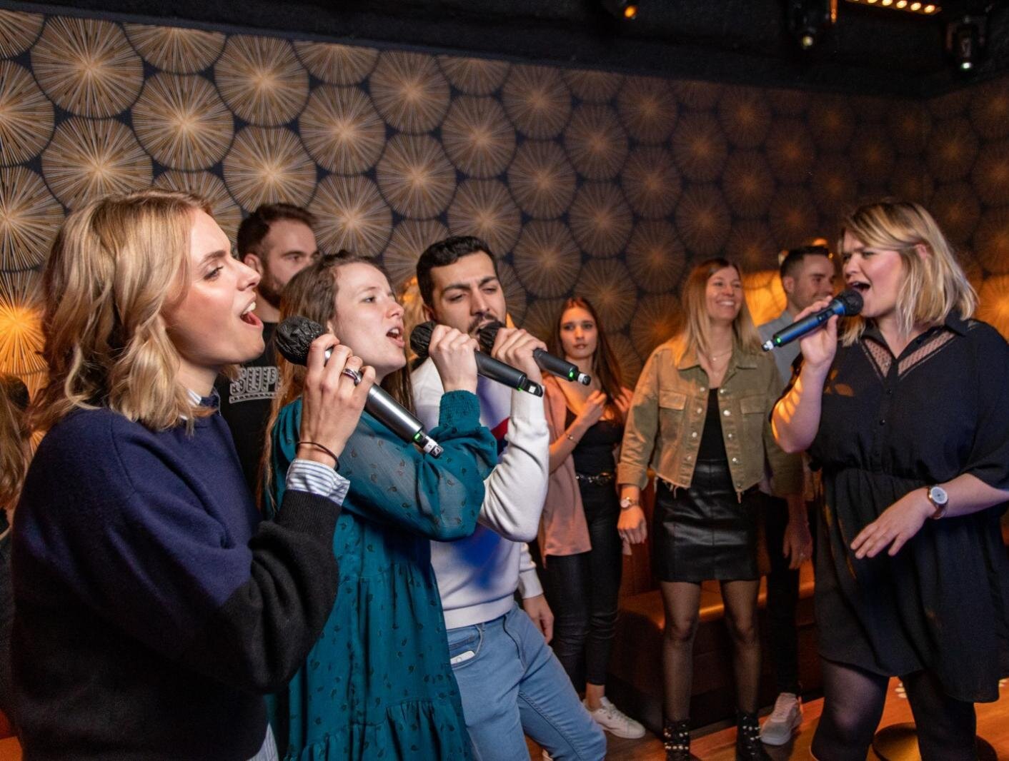 Groupe d'amis qui fêtent un anniversaire en chanson dans une salle privative du karaoké de Reims